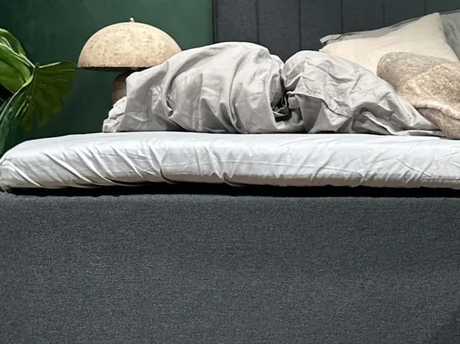 Nærbilde av FamBed-lakenet strukket over overmadrassen på en familieseng