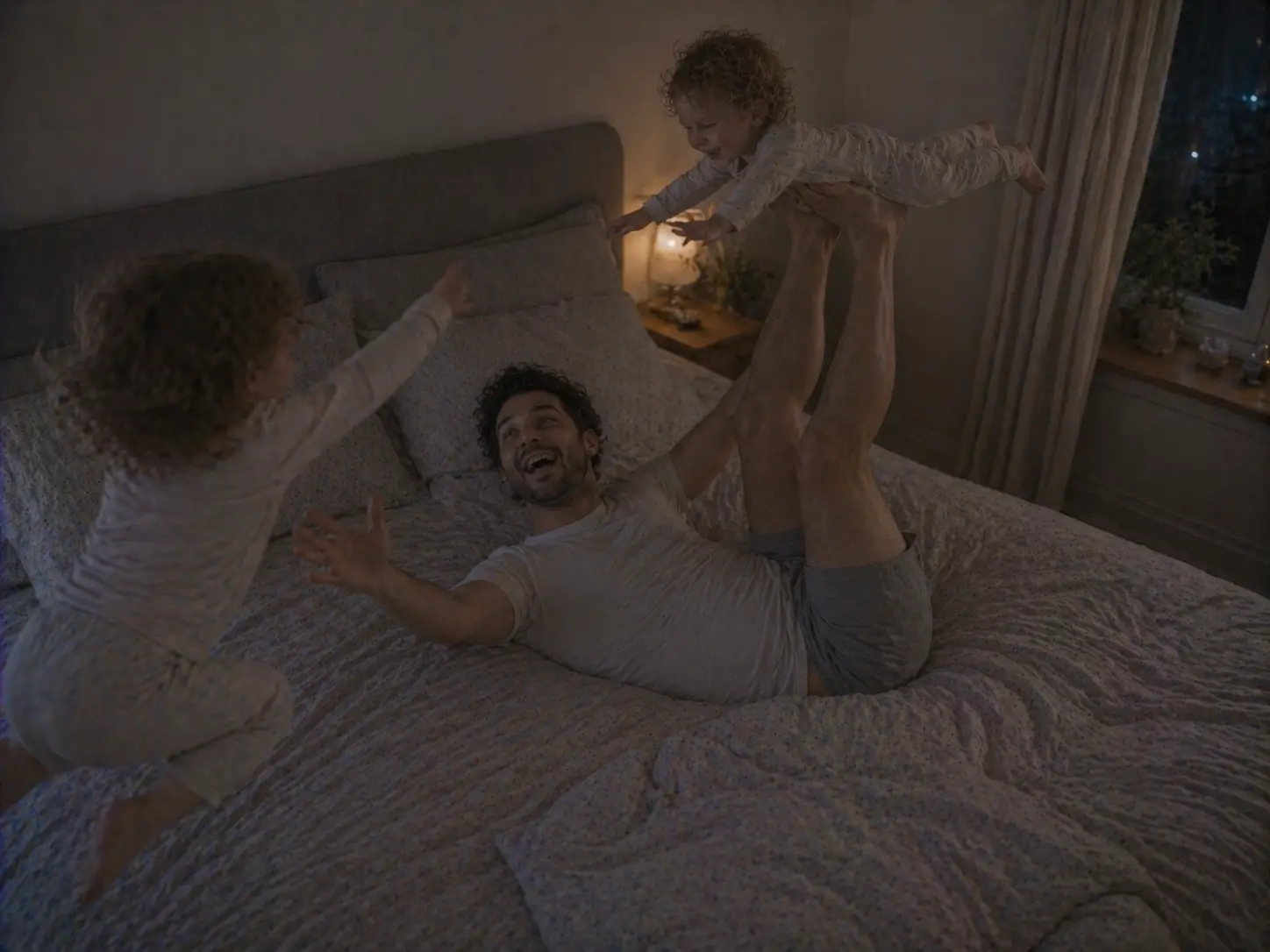 Far leker fly med det ene barnet på sengen, mens det andre hopper ved siden av